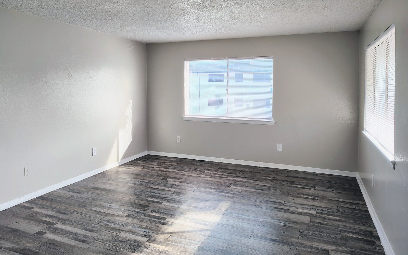 Sala con dos ventanas y piso de vinil tipo duela